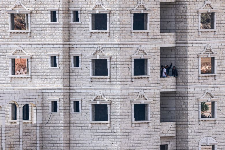 Israeli settlers perch on Palestinian homes under construction in the village of Qusra, which has faced escalating Jewish settler violence over the past month, on Sunday.