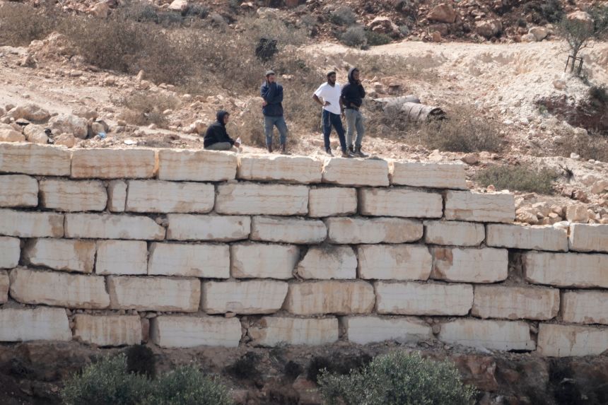 Israeli settlers enter Palestinian properties in Qusra, on Saturday. In recent months, settlers have rebuffed orders from the authorities to leave the area and tryied to force Palestinian families out.