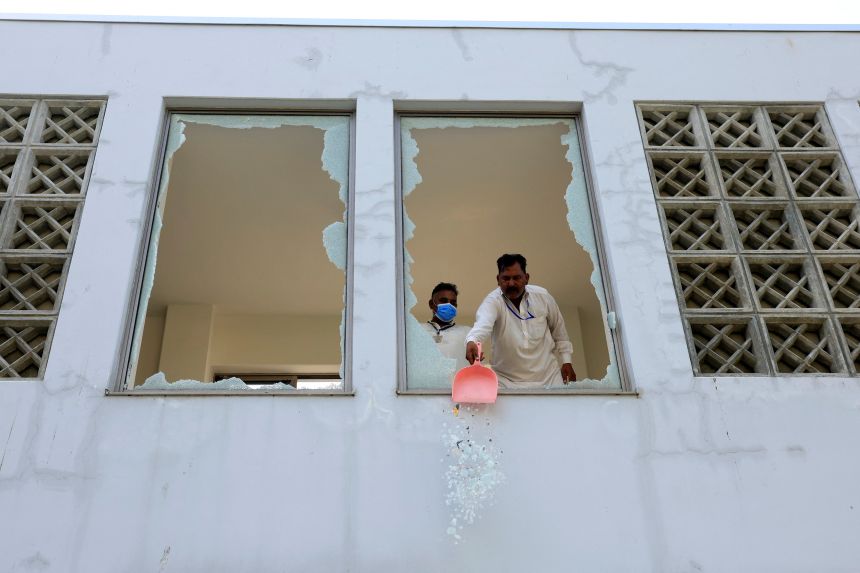 A worker removes broken pieces of a glass window after a fire broke out at the Pakistan Institute of Medical Sciences (PIMS) hospital in Islamabad, Pakistan, August 26, 2026.