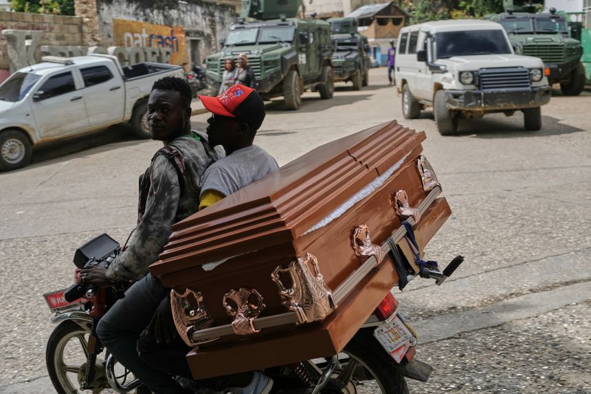 Men transport an empty coffin on a motorcycle in the Kenscoff neighborhood of Port-au-Prince., Haiti, Tuesday, Aug. 25.