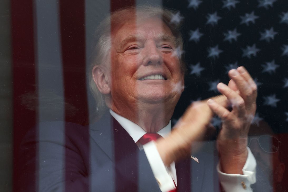 An American flag is reflected off bulletproof glass as U.S. President Donald Trump watches the end of the NTT INDYCAR Series on August 23 in Washington, DC.