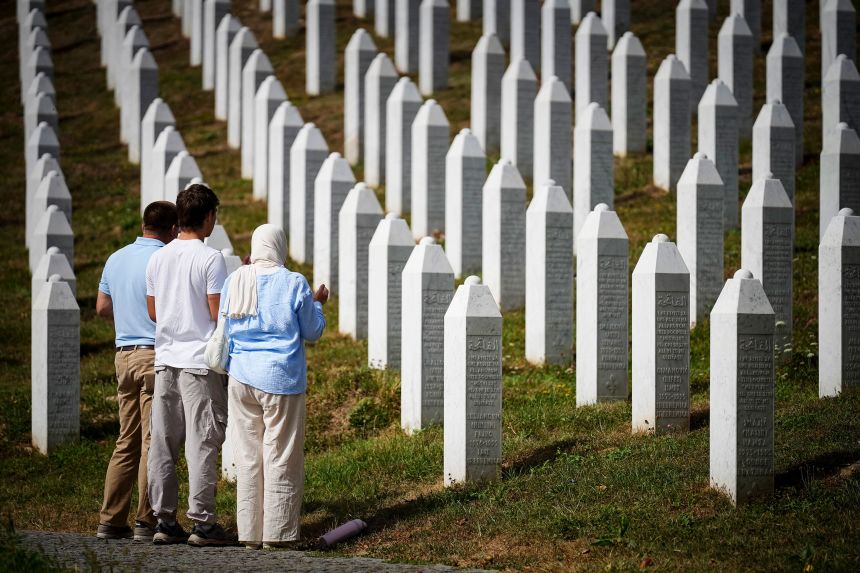 Visitors stand at the memorial cemetery in the village of Potocari, near the eastern Bosnian town of Srebrenica, on Friday.